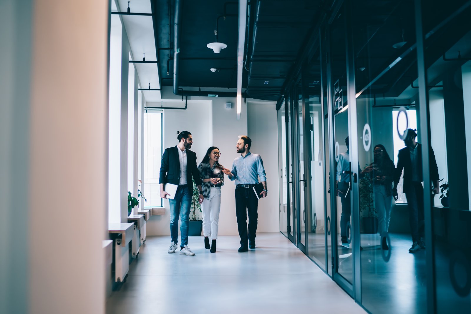 Professional team walking through modern office corridor